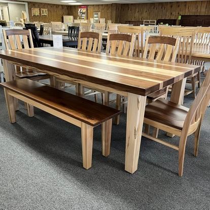 A wooden table with chairs and a bench in a room.