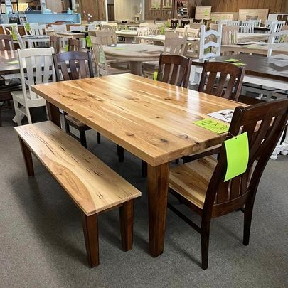 A wooden table with chairs and a bench in a store.