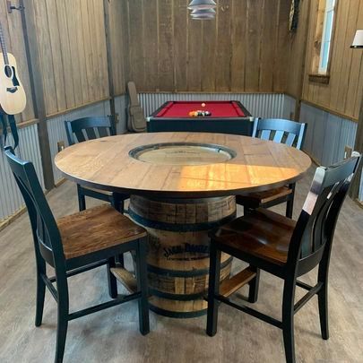 A room with a pool table and a table made out of a barrel