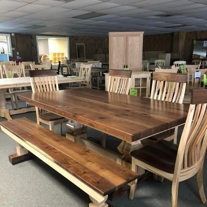 A wooden table with a bench and chairs in a room