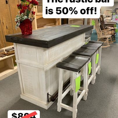 A bar with stools and a vase of flowers on top of it is 50 % off.