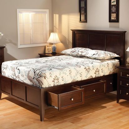 A bedroom with a bed with drawers underneath it