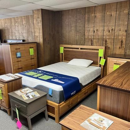 A bedroom with a bed , nightstands , dressers and a mattress.