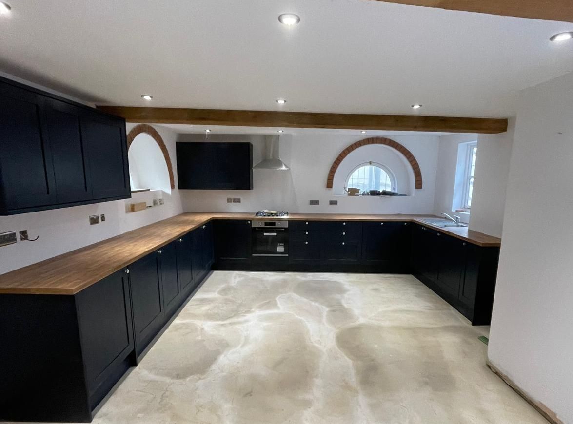 A kitchen with black cabinets and wooden counter tops.