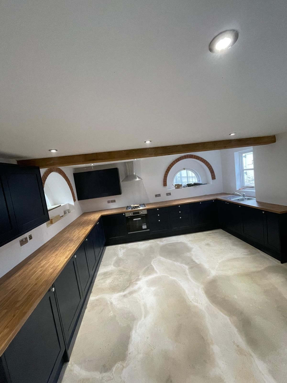 A kitchen with black cabinets and wooden counter tops.