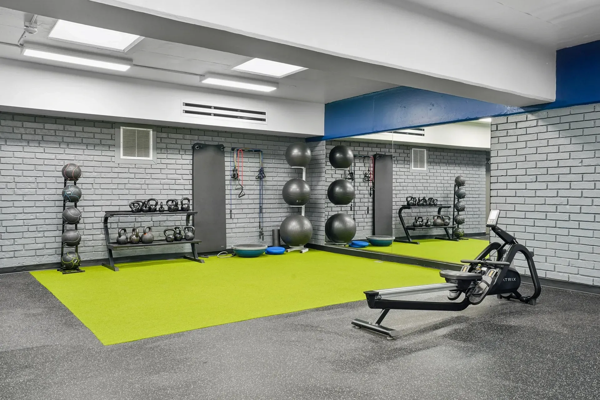 Gym with rowing machine, yoga balls, and weights.