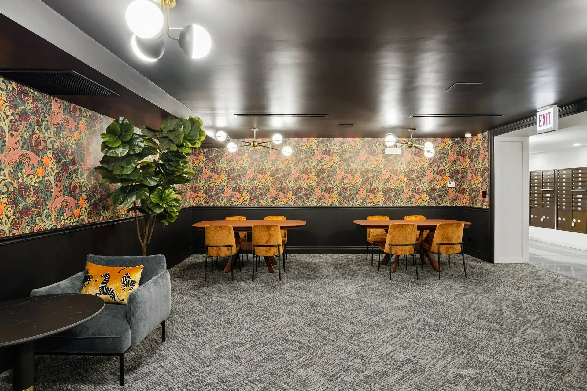 Stylish lounge area with plush seating, accent wallpaper, and dining tables.