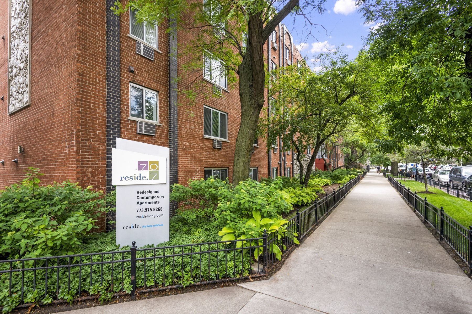Reside 7 apartment building exterior with walkway and landscaping