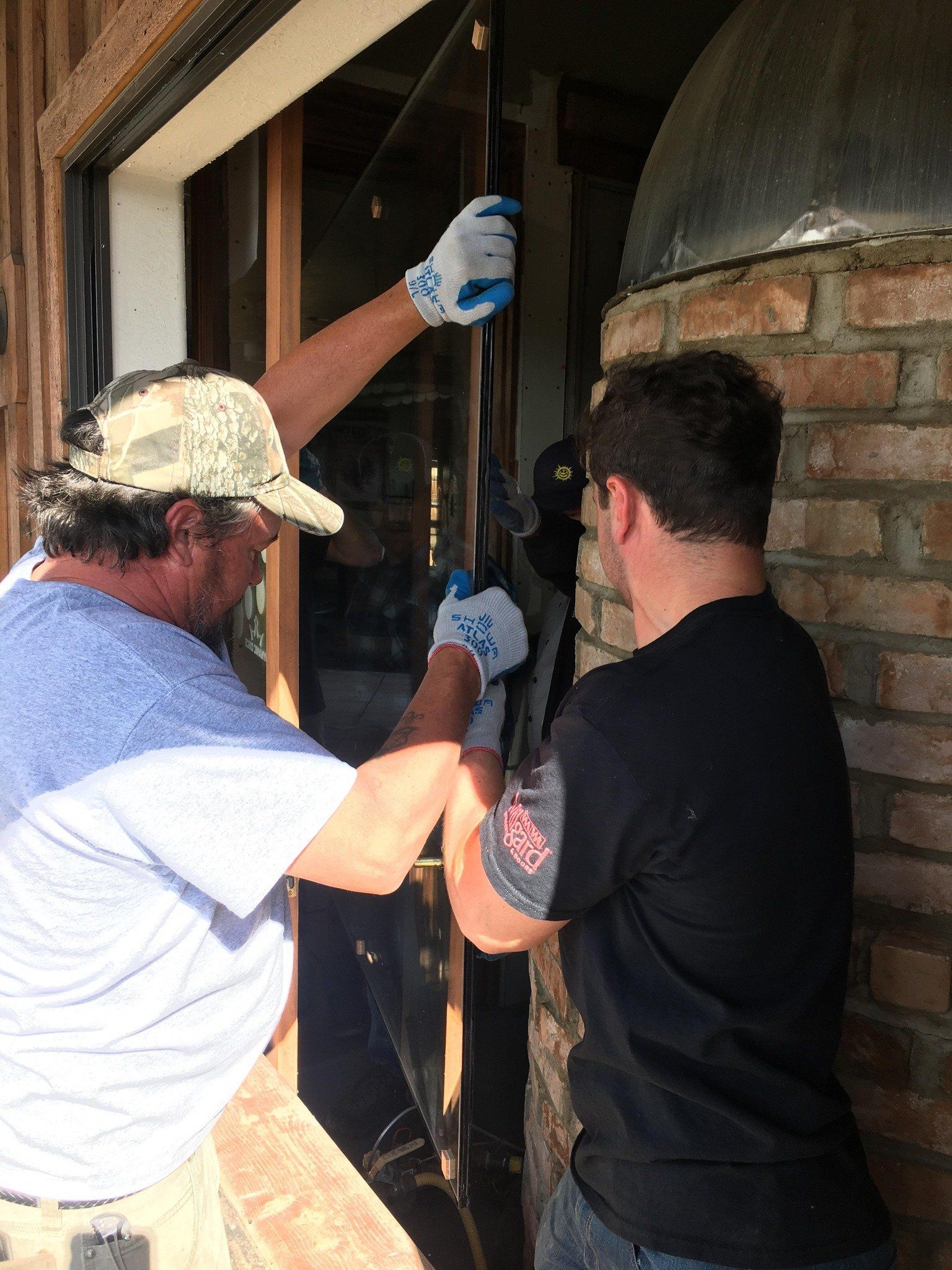 Sunglass employees installing a window providing residential services