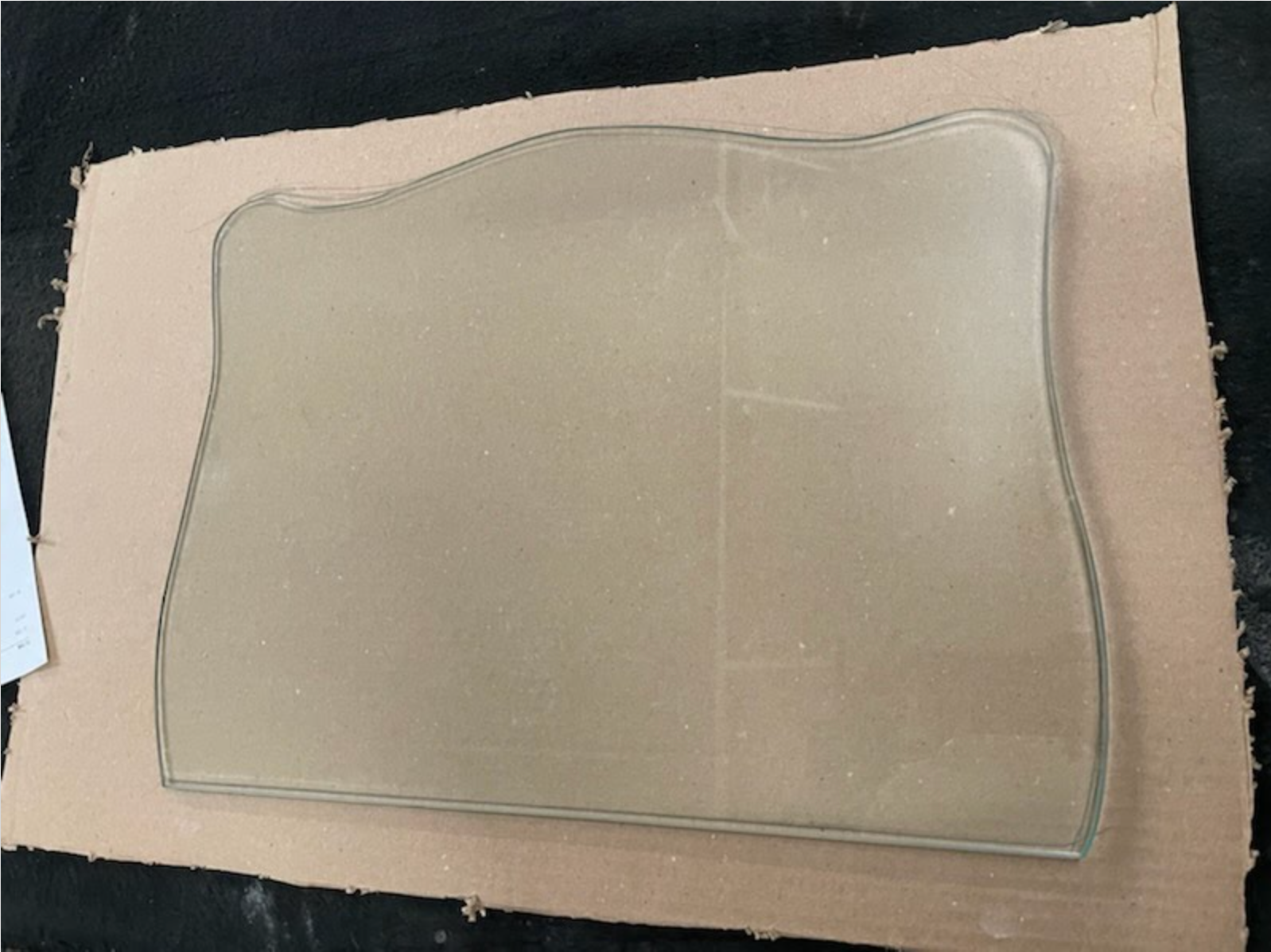 A piece of glass is sitting on a piece of cardboard