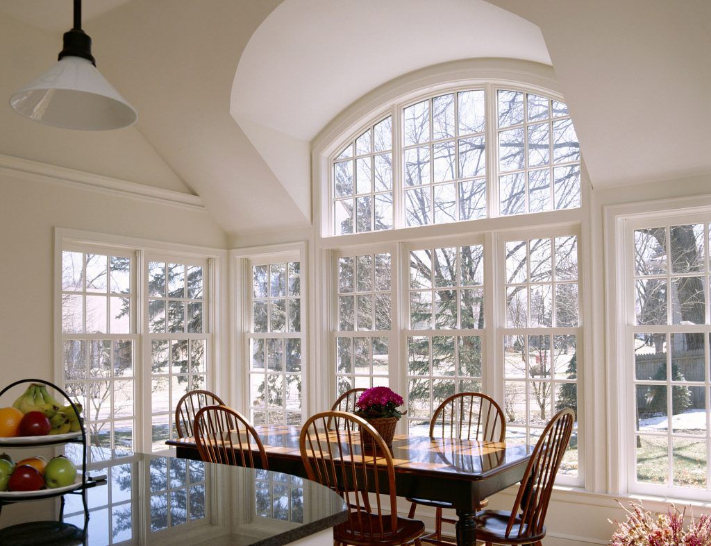 a dining room with a table and chairs and lots of windows installed by Sunglass