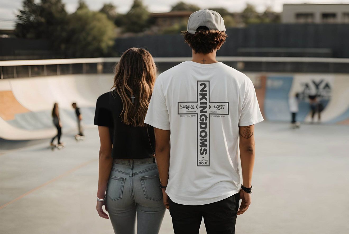 Couple in a skate park, man wearing a white shirt with a cross, woman in black.