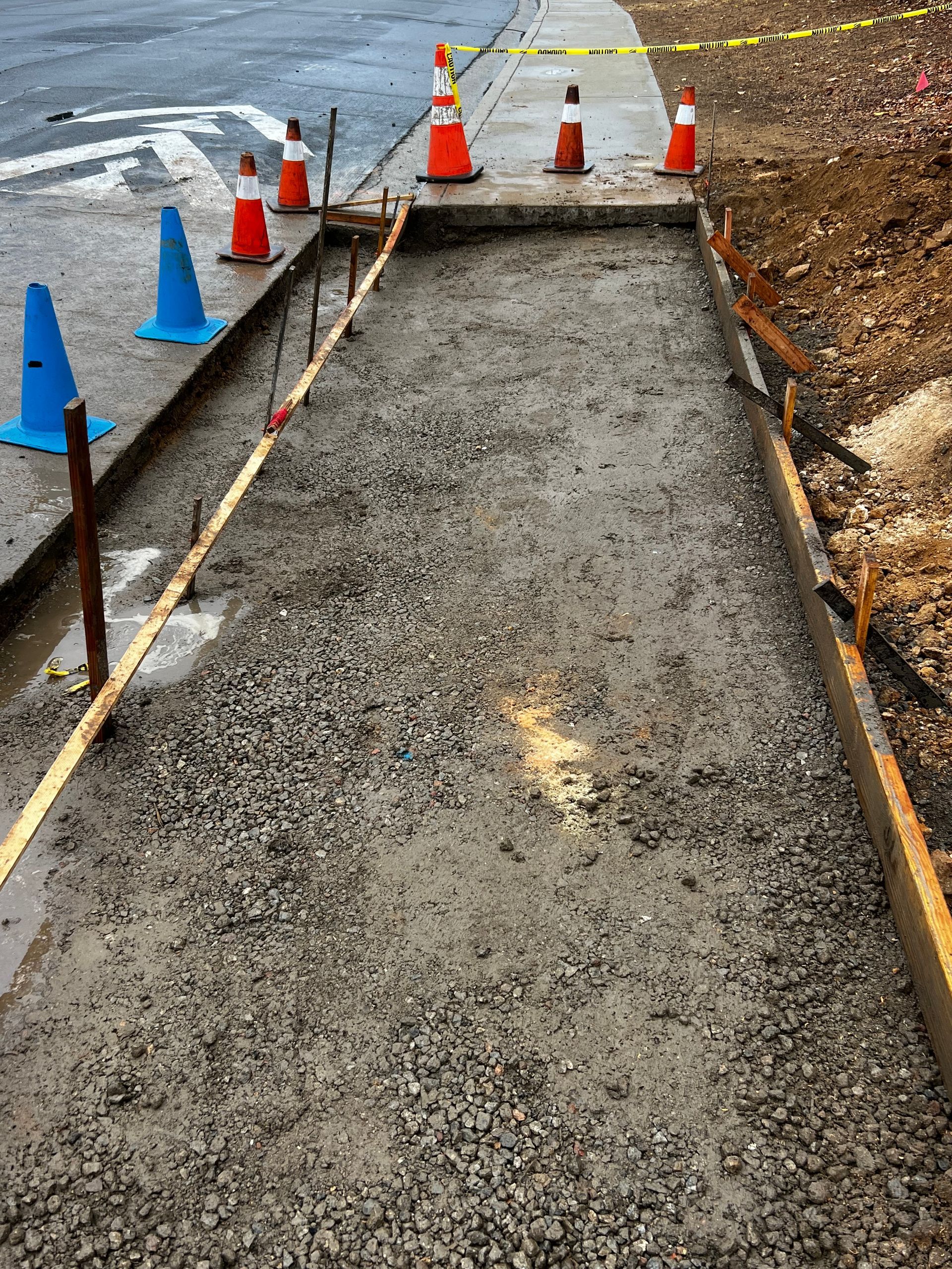 A concrete sidewalk is being built next to a road.