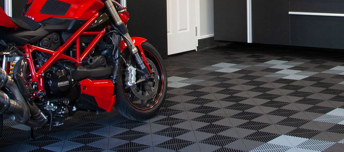 Red motorcycle parked on a black-and-gray checkered floor in a garage or showroom.