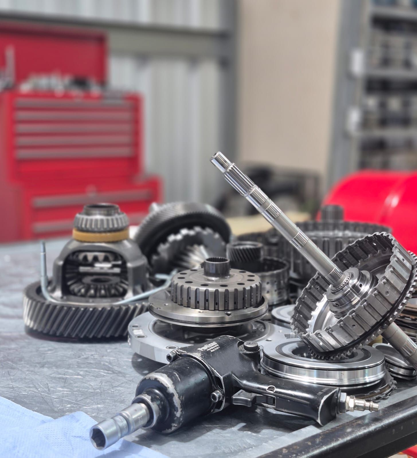 Mecánico inspeccionando la transmisión de un automóvil en un taller mecánico.