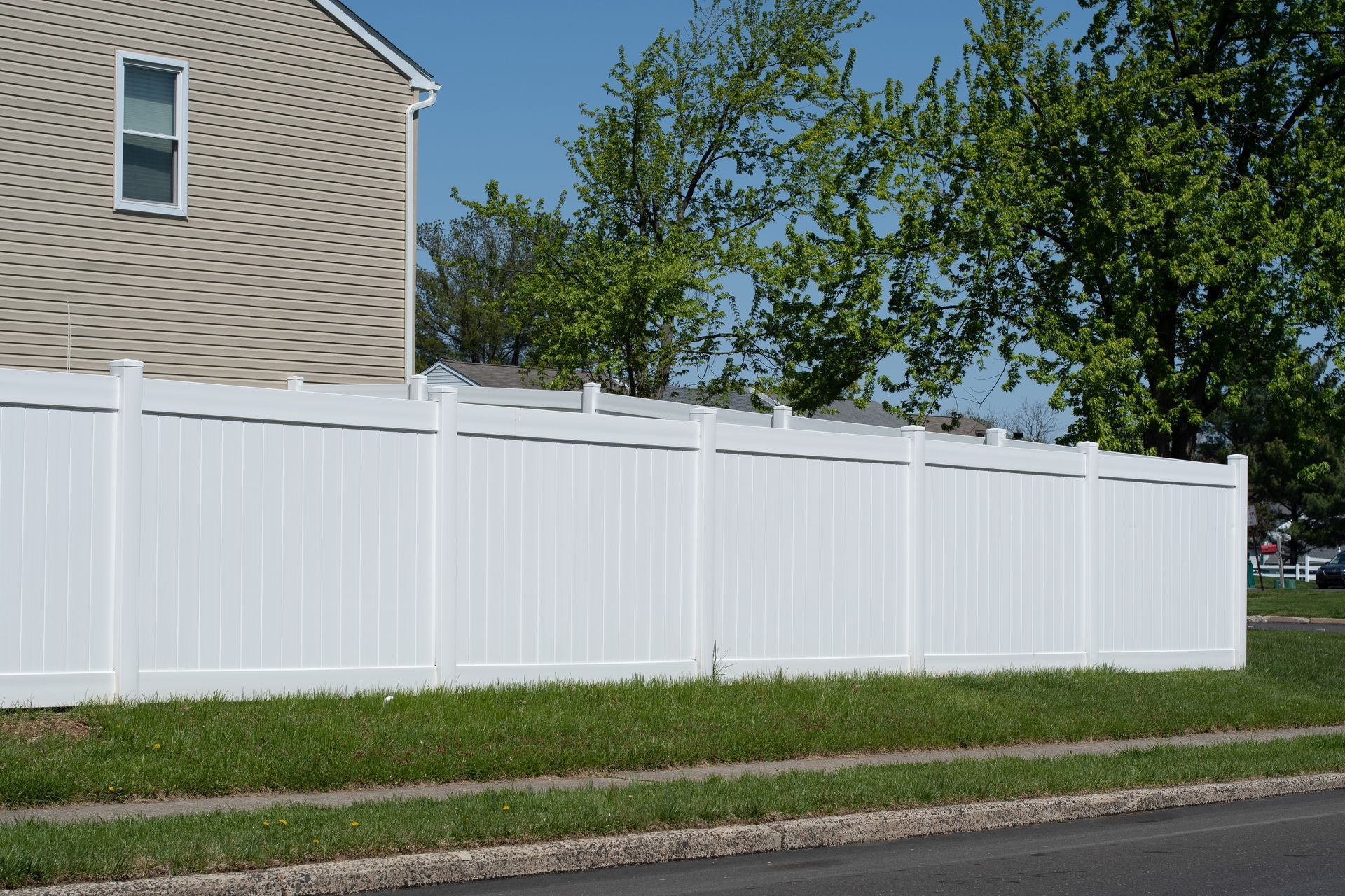 A white fence with a house in the background
