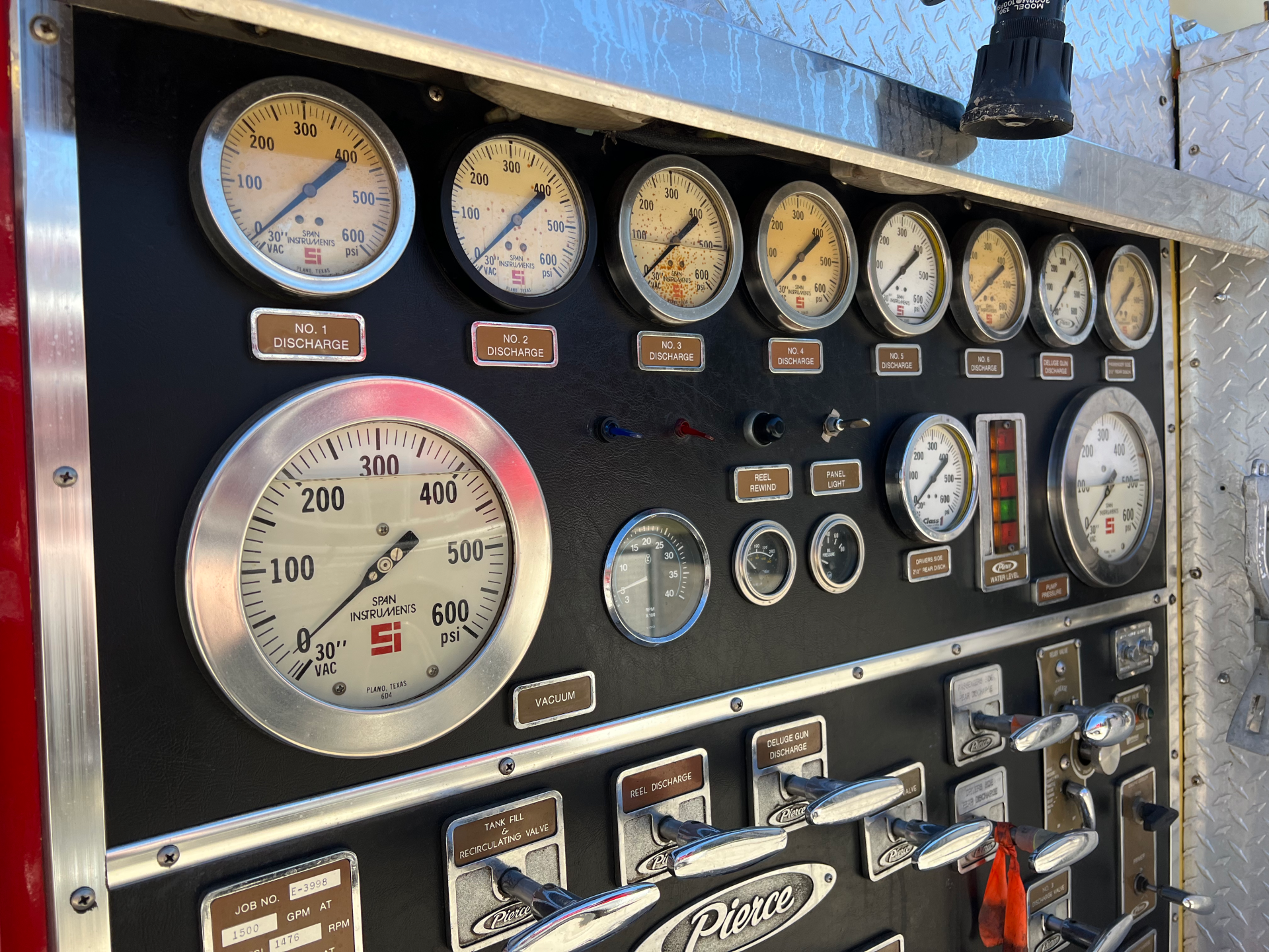 A dashboard of a fire truck with many gauges and buttons