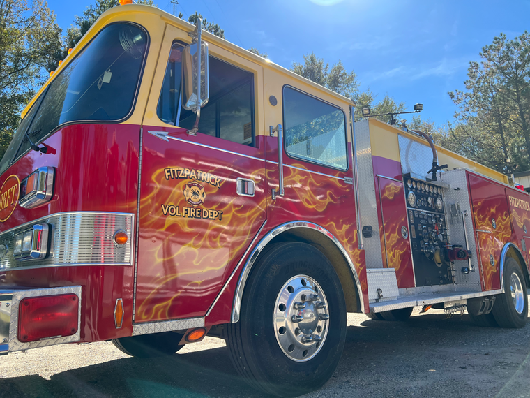 A red and yellow fire truck with flames painted on it