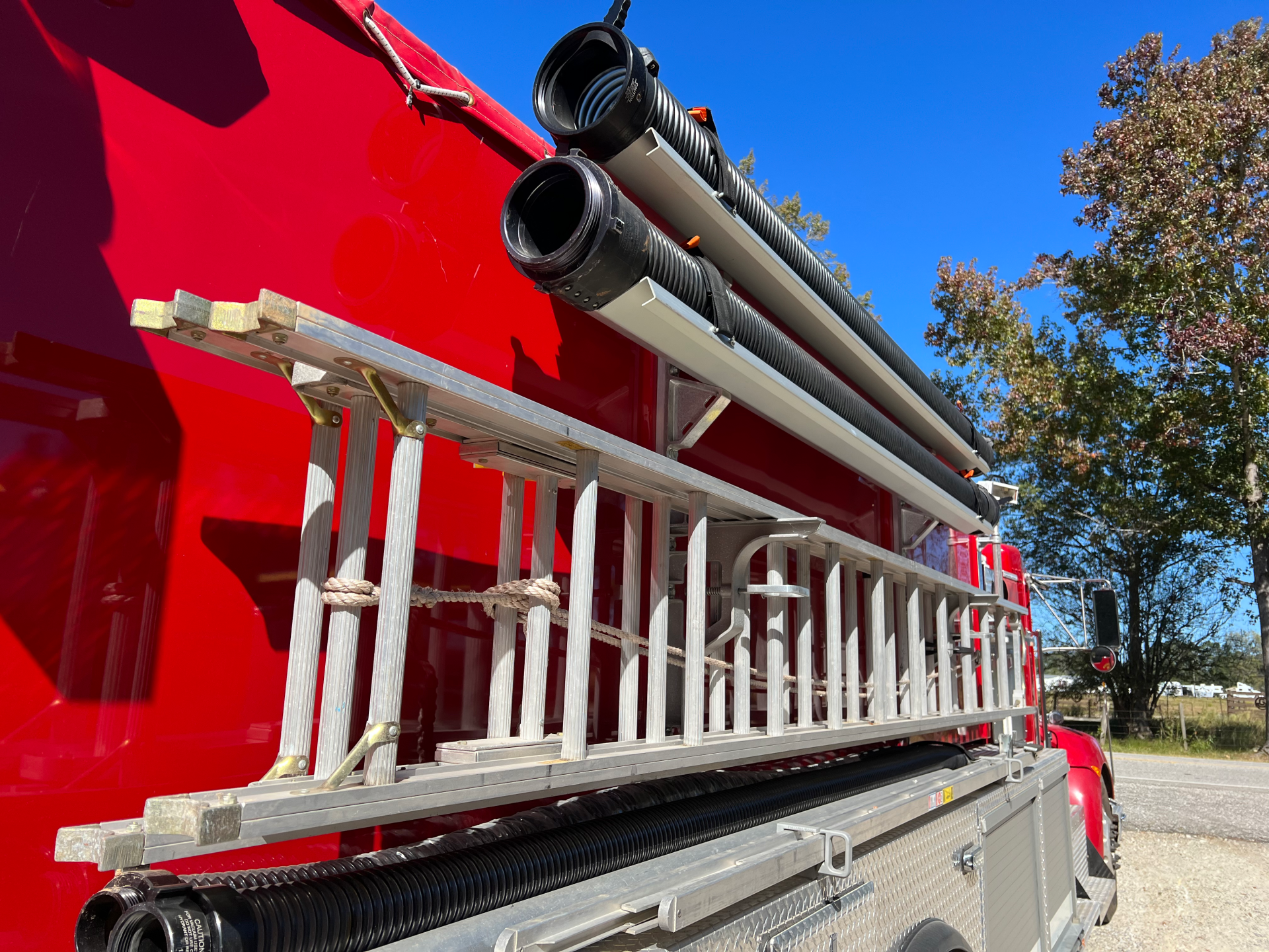 A red fire truck with a ladder on the back of it.