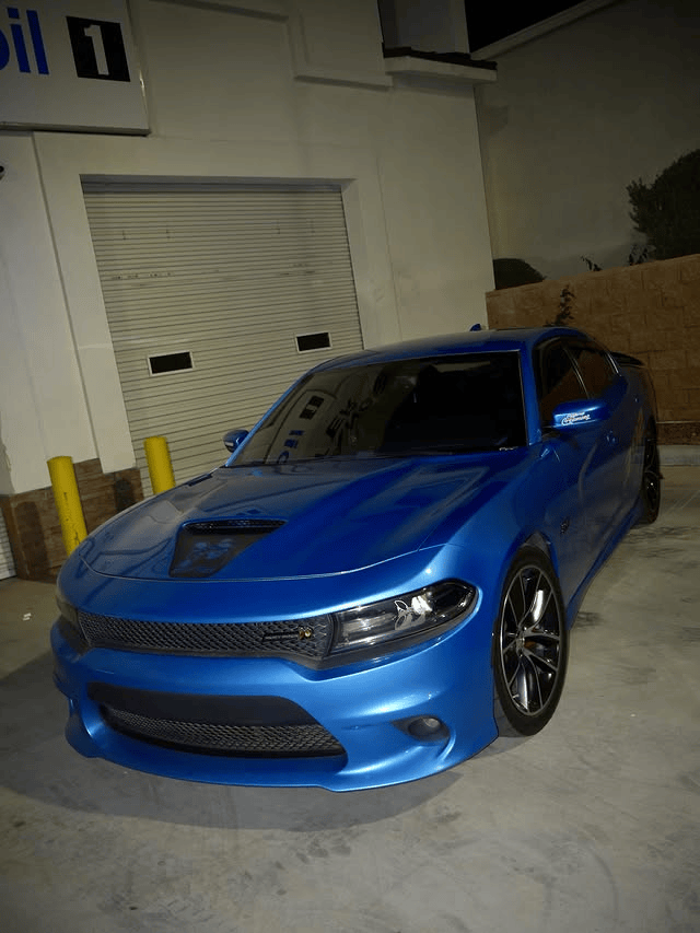 Blue sports car parked outside a building at night