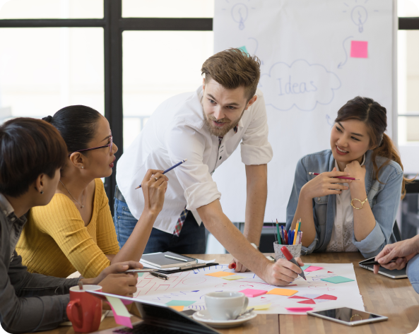 A group of people are sitting around a table having a meeting.