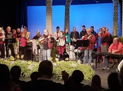 A group of people are standing on a stage playing instruments.