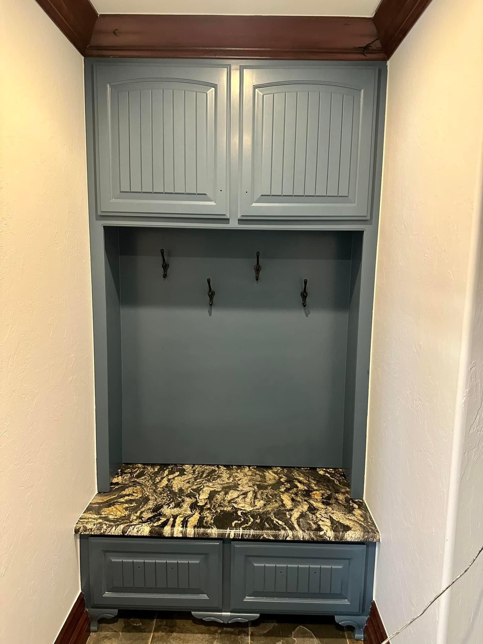 A hallway with a gray cabinet and a marble counter top.