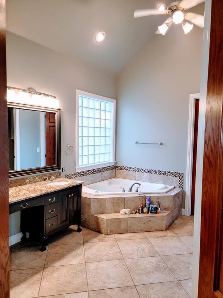A bathroom with a jacuzzi tub and a ceiling fan