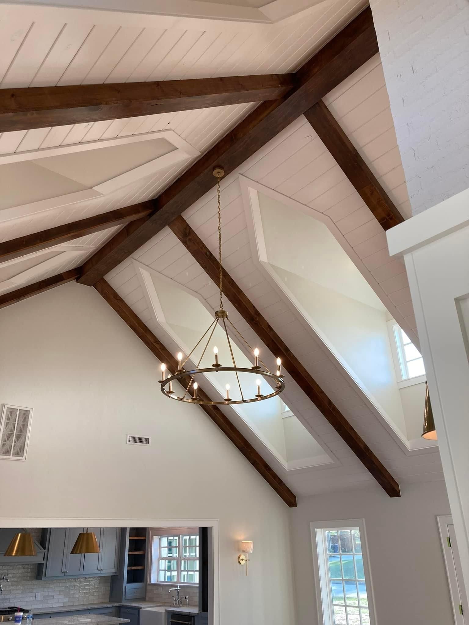 A chandelier is hanging from the ceiling of a room with a vaulted ceiling.