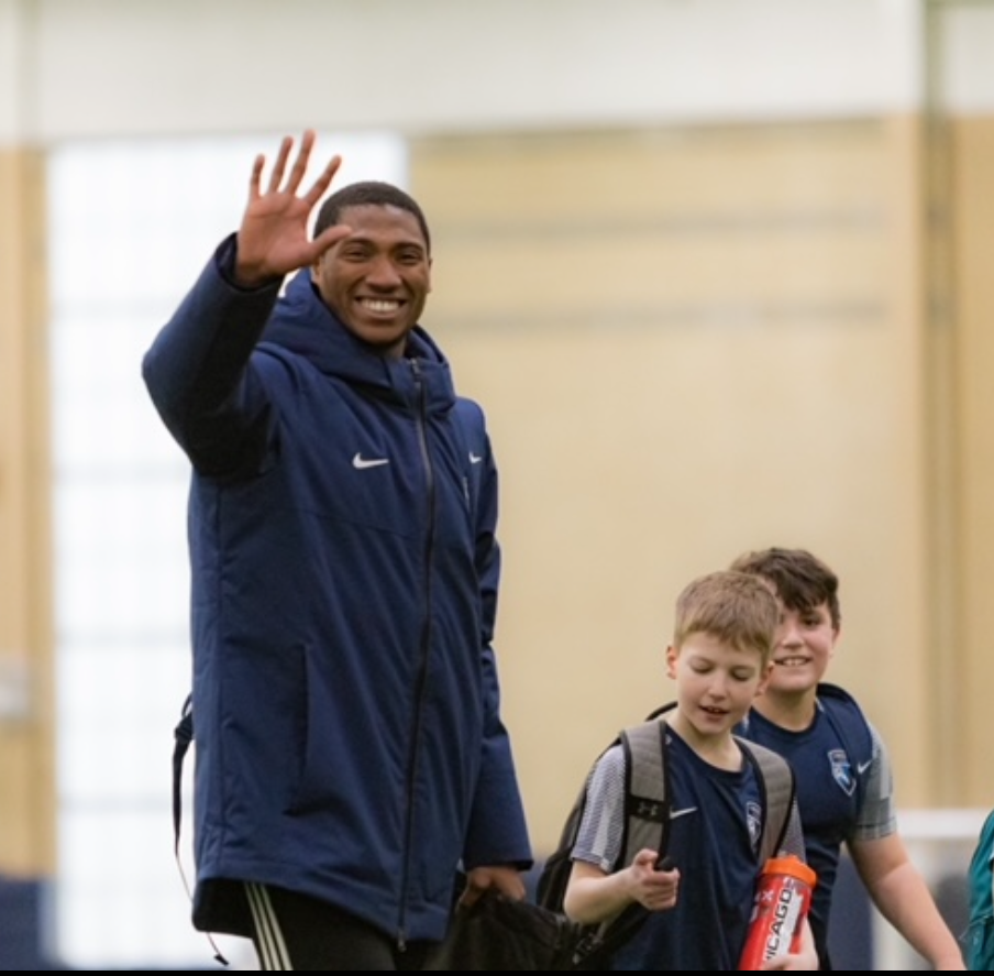 A man in a blue nike jacket is waving