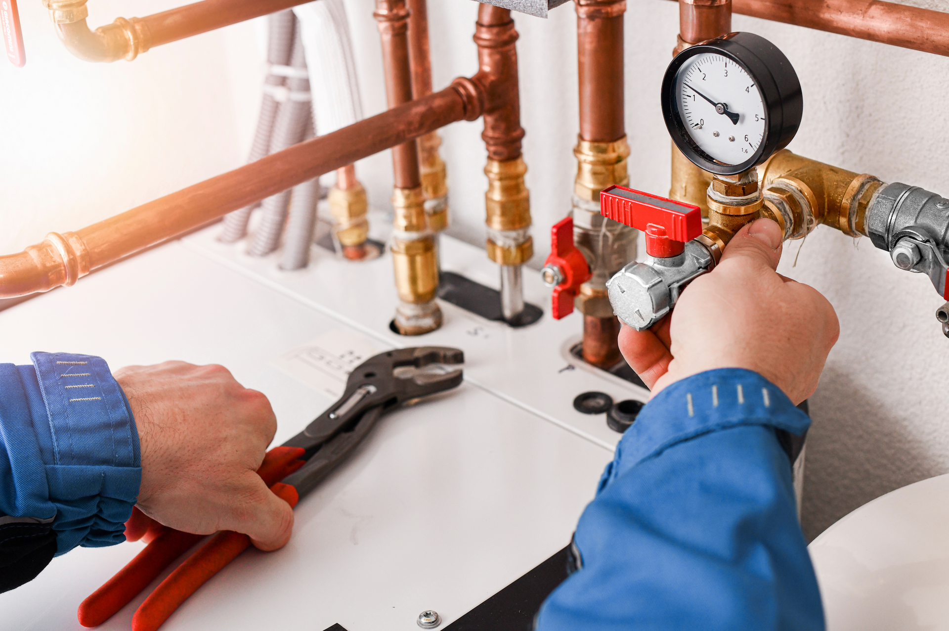 A plumber is working on a pipe with a wrench.