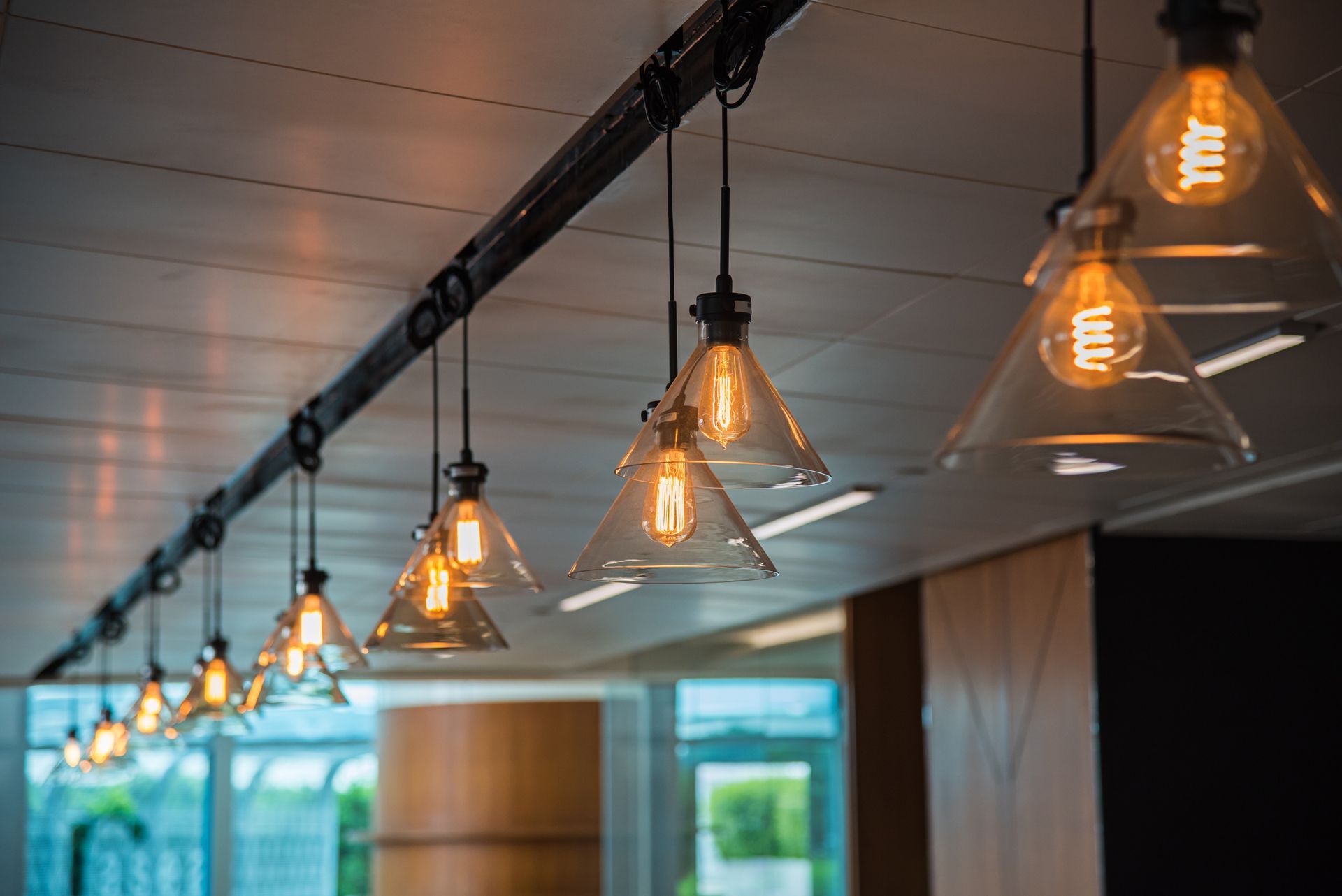 A row of light bulbs hanging from the ceiling in a room.