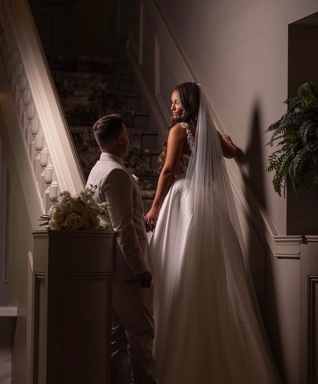 A woman is trying on a wedding dress in a bridal shop.
