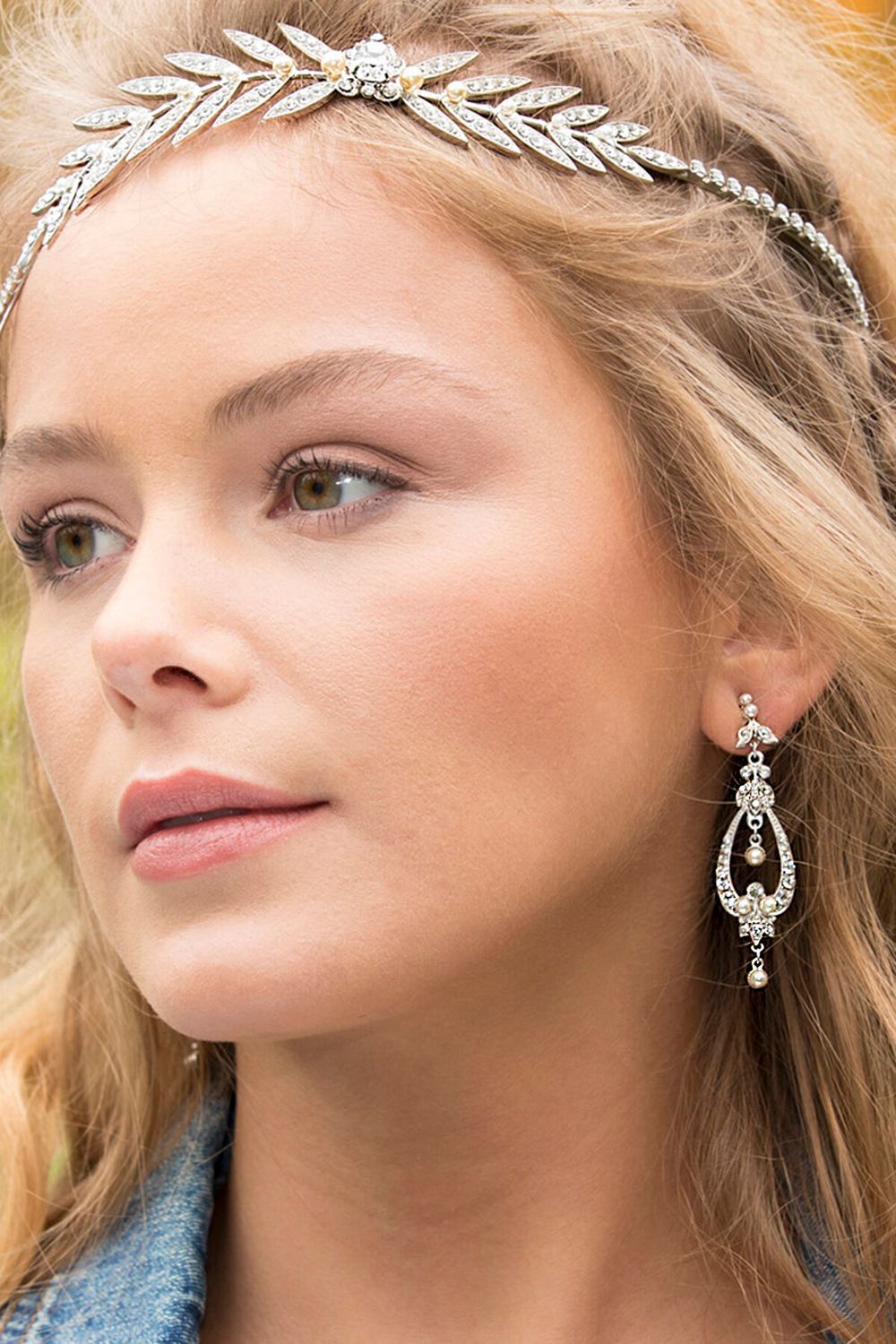 A close up of a woman wearing a headband and earrings.