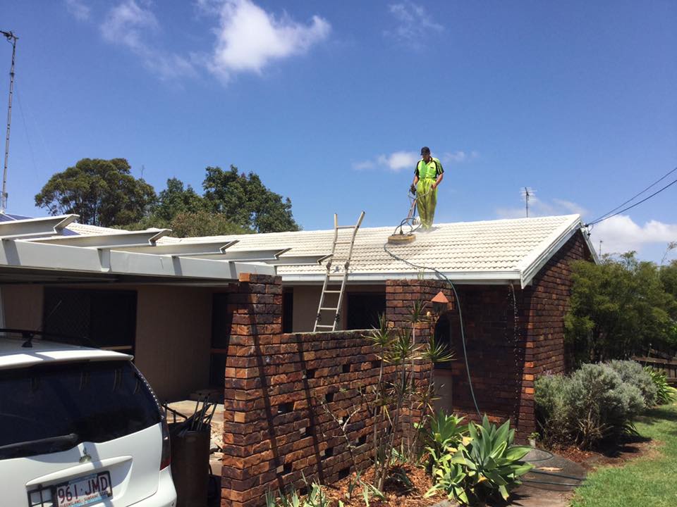 A Worker Cleaning In Roof House — O & D House Wash & Cleaning Services in Glenvale, QLD