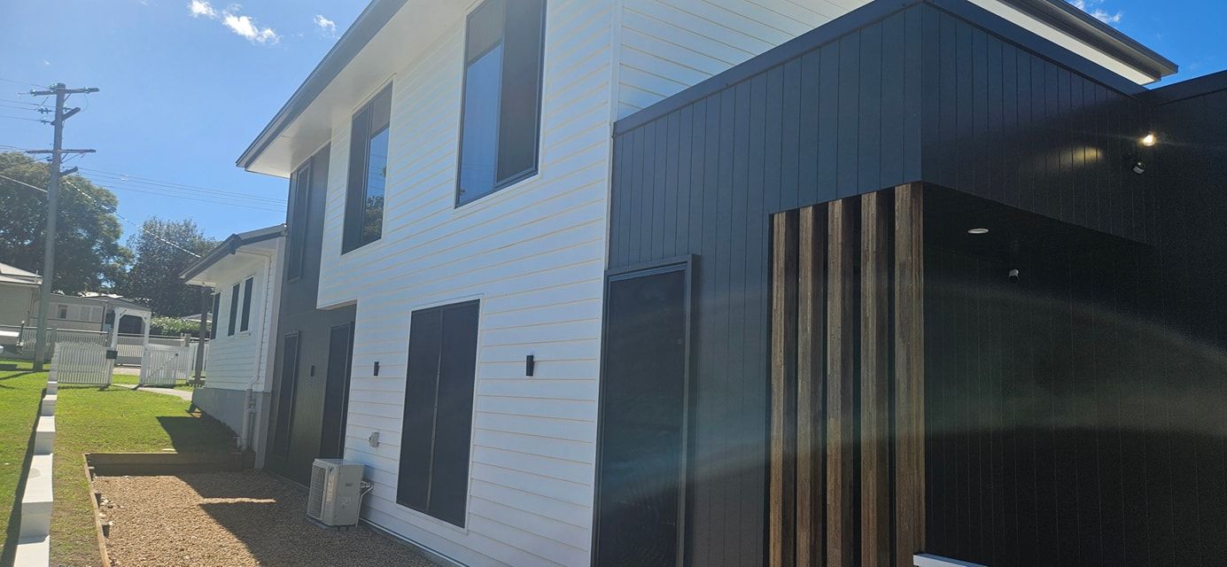 A white house with black trim and a lot of windows on a sunny day. — O & D House Wash & Cleaning Services in Highfields, QLD