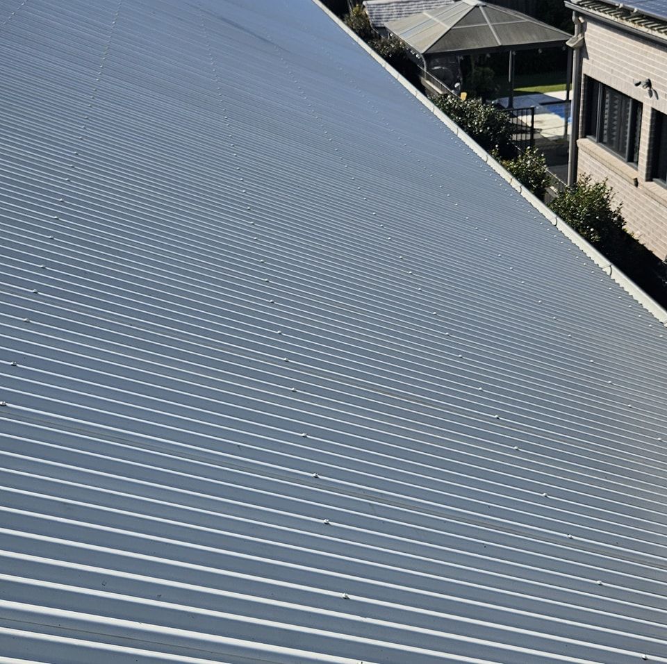 A close up of a metal roof with a house in the background. — O & D House Wash & Cleaning Services in Oakey, QLD