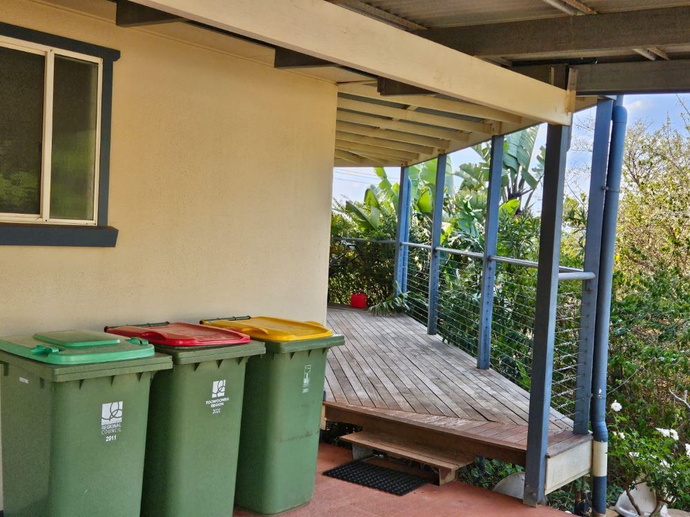 A bunch of trash cans are sitting on a porch — O & D House Wash & Cleaning Services in Glenvale, QLD
