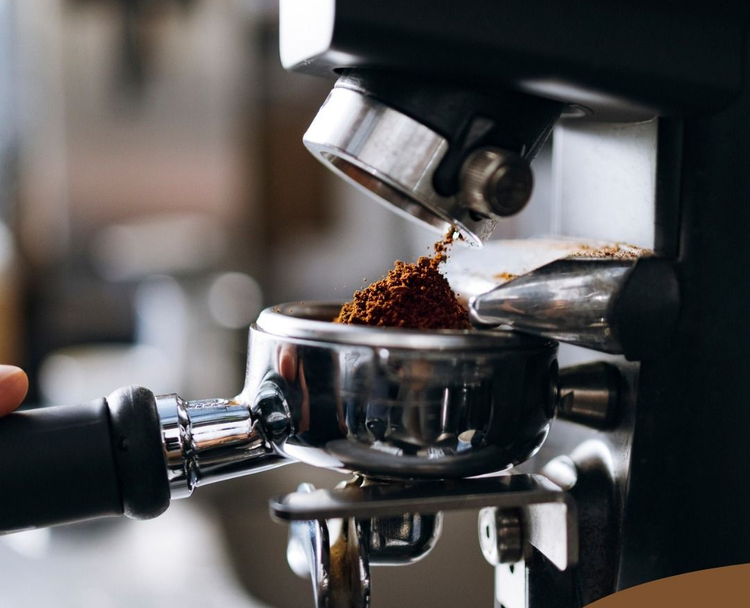 Un portafiltro posizionato sotto un macinacaffè, che raccoglie la polvere di caffè espresso fresca in una macchina da caffè domestica.