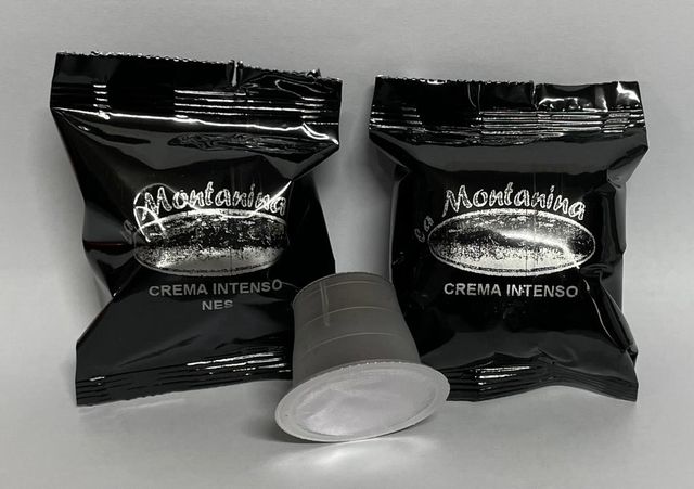 Due involucri neri di capsule di caffè con l'etichetta "La Montanina Crema Intenso" e una singola capsula di caffè al centro.