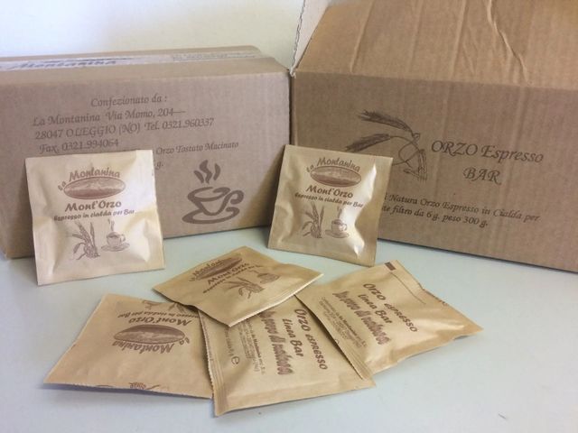 Scatole di cartone con l'etichetta "Orto Espresso Bar" e diverse confezioni di caffè di marca color beige disposte sul davanti.