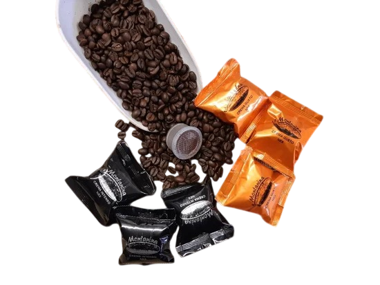 Un cucchiaio bianco che versa chicchi di caffè tostati su una piccola capsula, circondata da involucri di caffè neri e dorati.