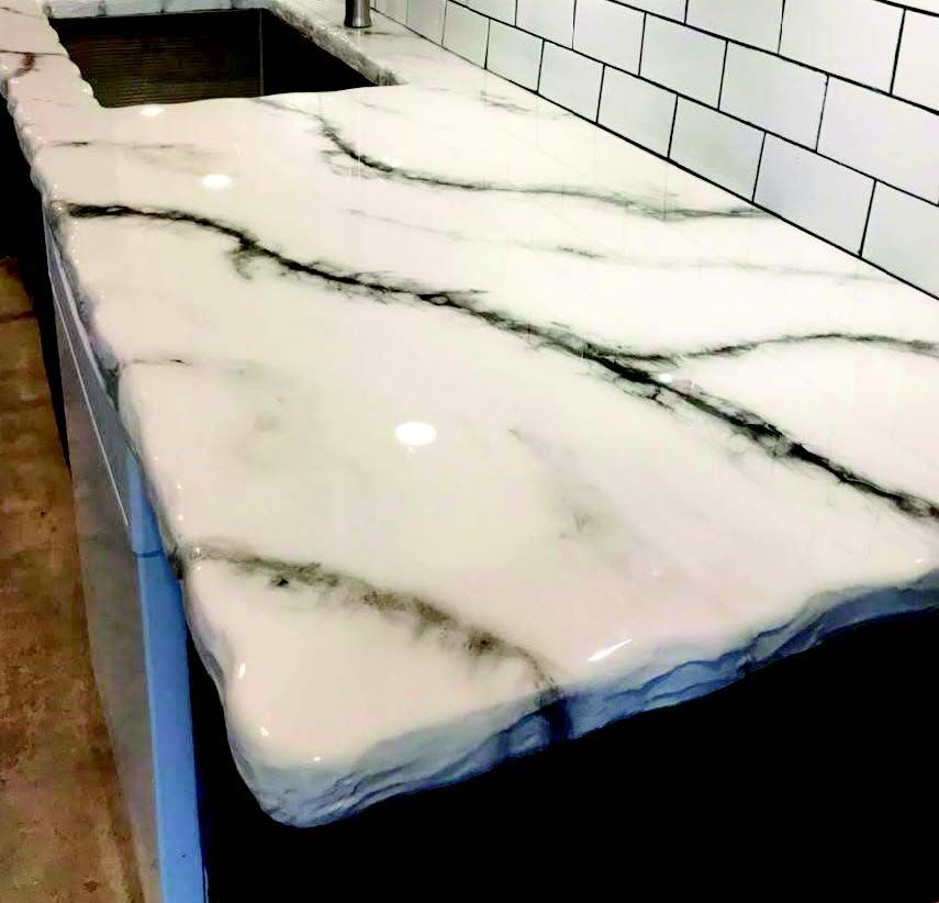White marble countertop with dark gray veins beside white subway tile backsplash