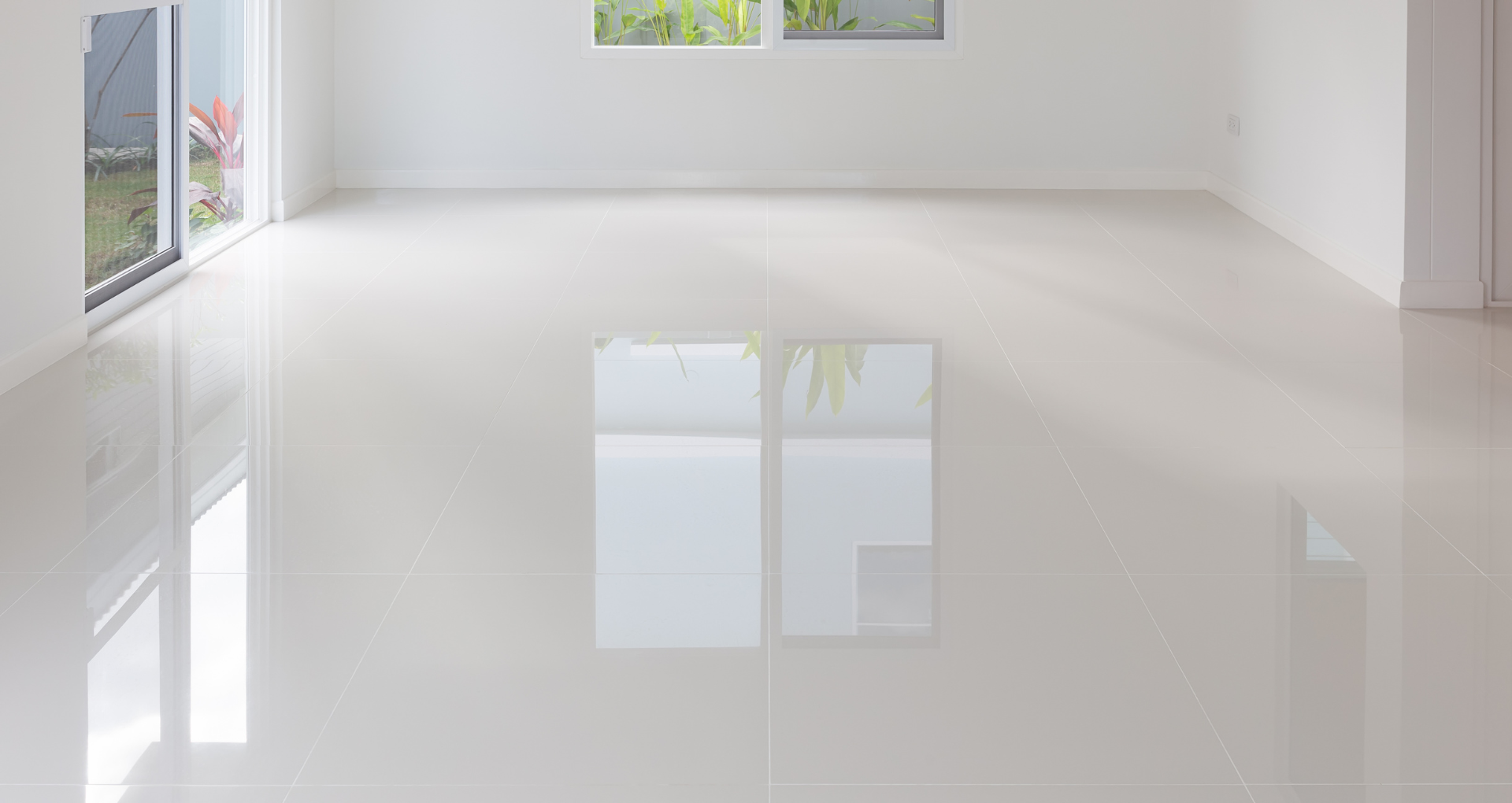 Bright empty white room with glossy floor and large windows reflecting light
