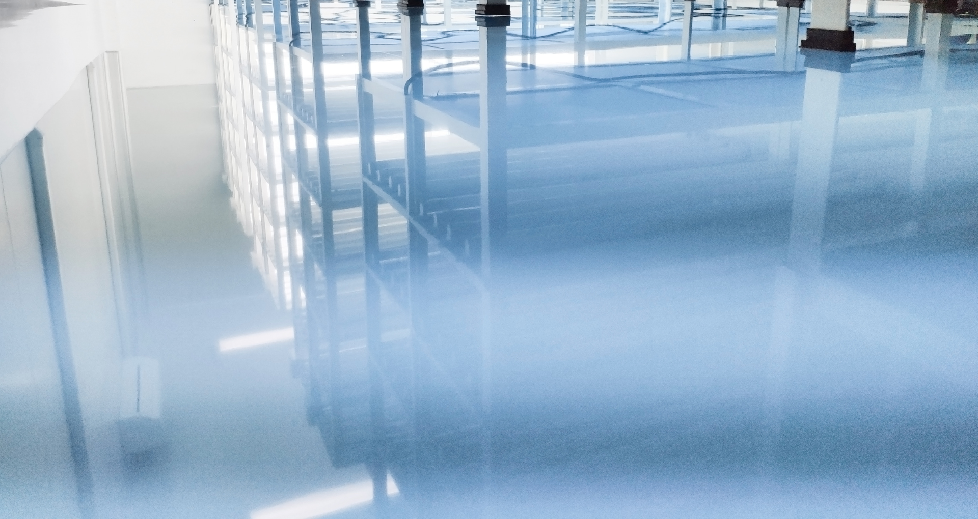 Empty bright room with glossy light blue floor and white walls reflecting windows