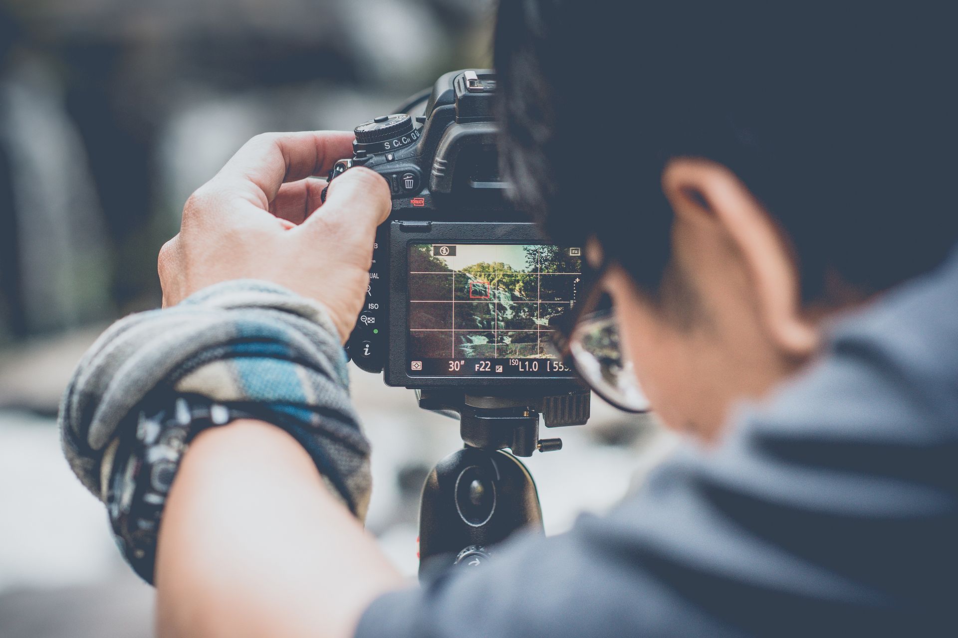 A person is taking a picture with a camera on a tripod