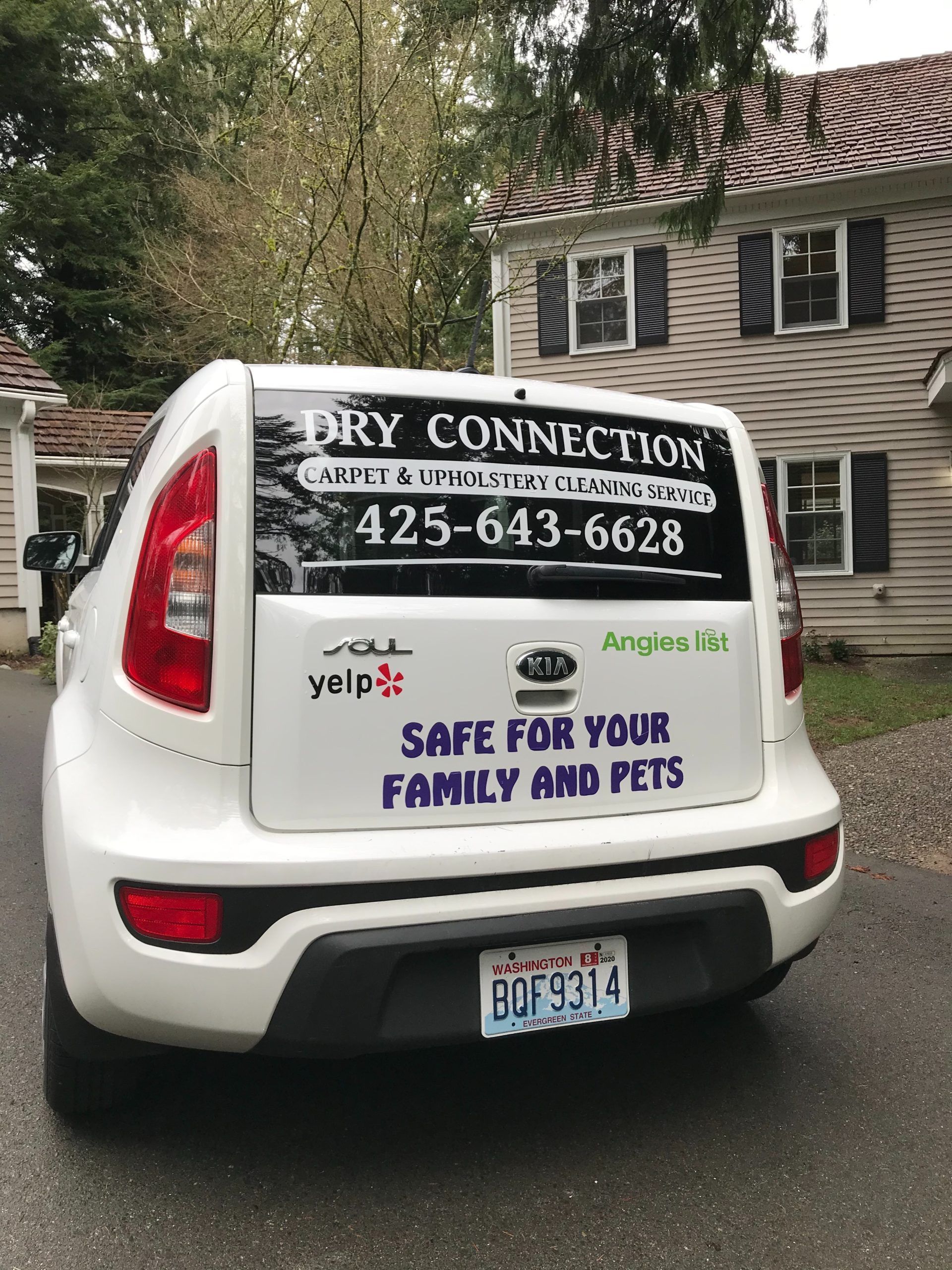 White service van with “Dry Connection” signs and phone number parked outdoors, “Safe for your family and pets” on back.