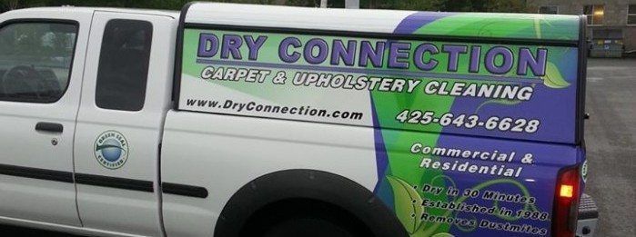 White Dry Connection cleaning truck with colorful business logo and phone number on the side