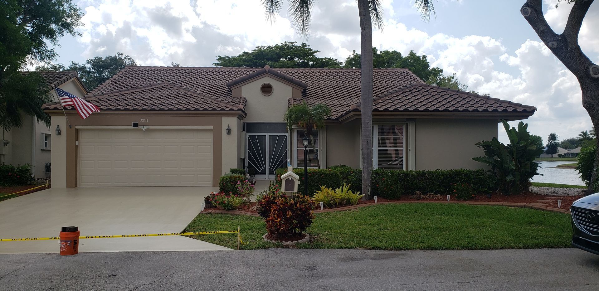Single-story suburban house with a two-car garage, tiled roof, and landscaped front yard.