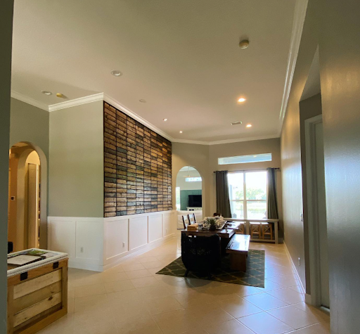 Bright dining room with patterned wall, wooden table, and large window overlooking greenery